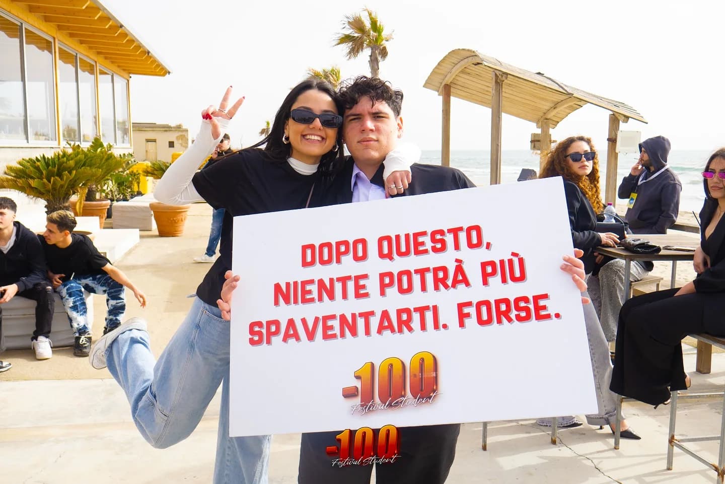 Due ragazzi mostrano un cartello con la scritta «Dopo questo, niente potrà più spaventarti. Forse».