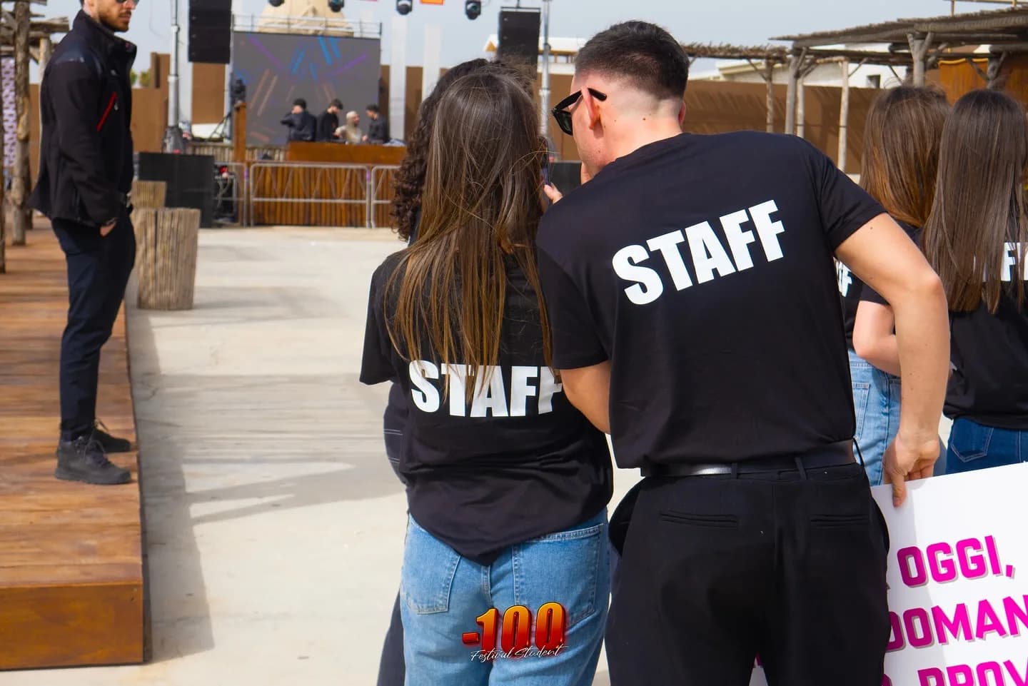 Due ragazzi di spalle con la maglietta «Staff».