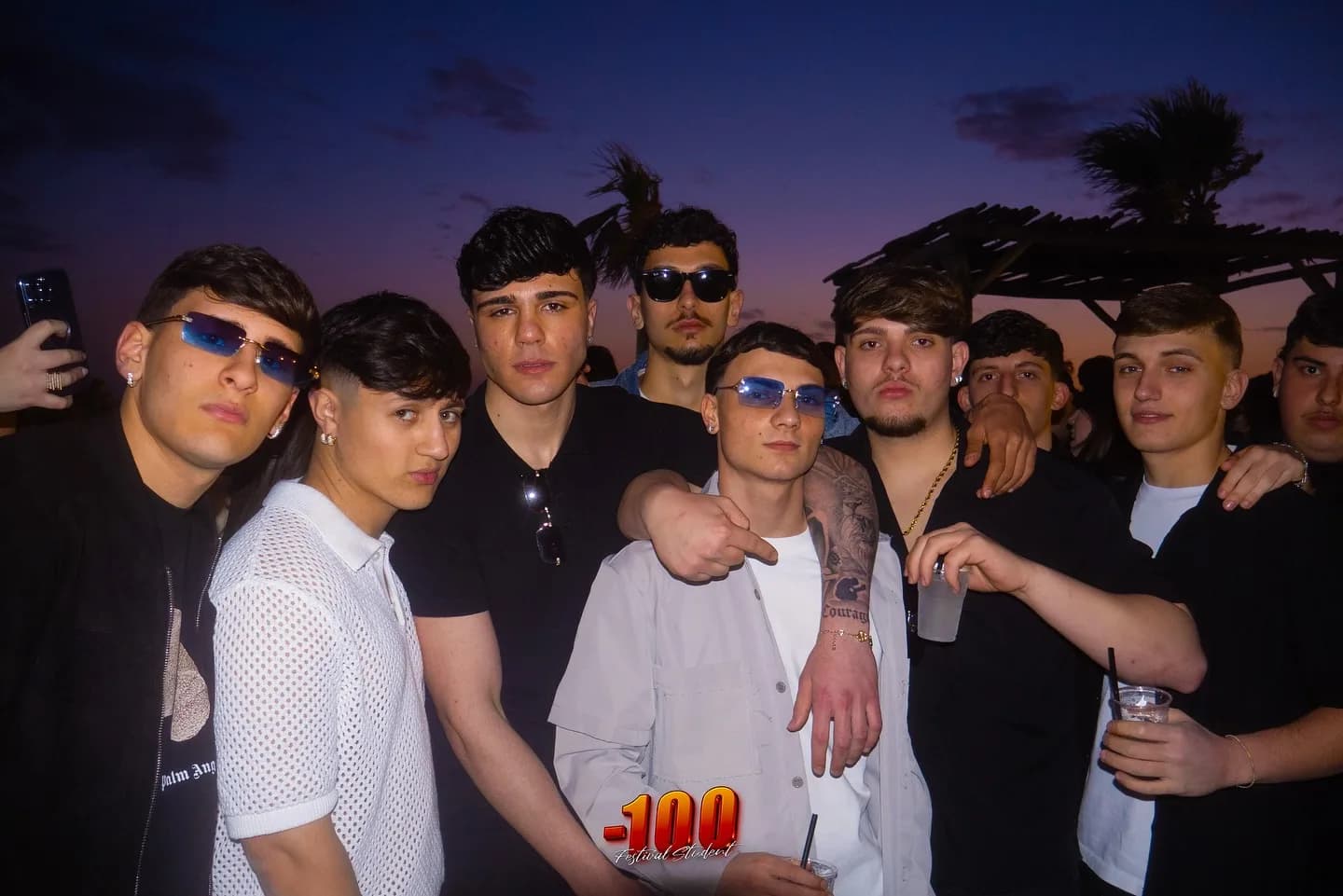 Gruppo di ragazzi in posa sulla spiaggia al tramonto.
