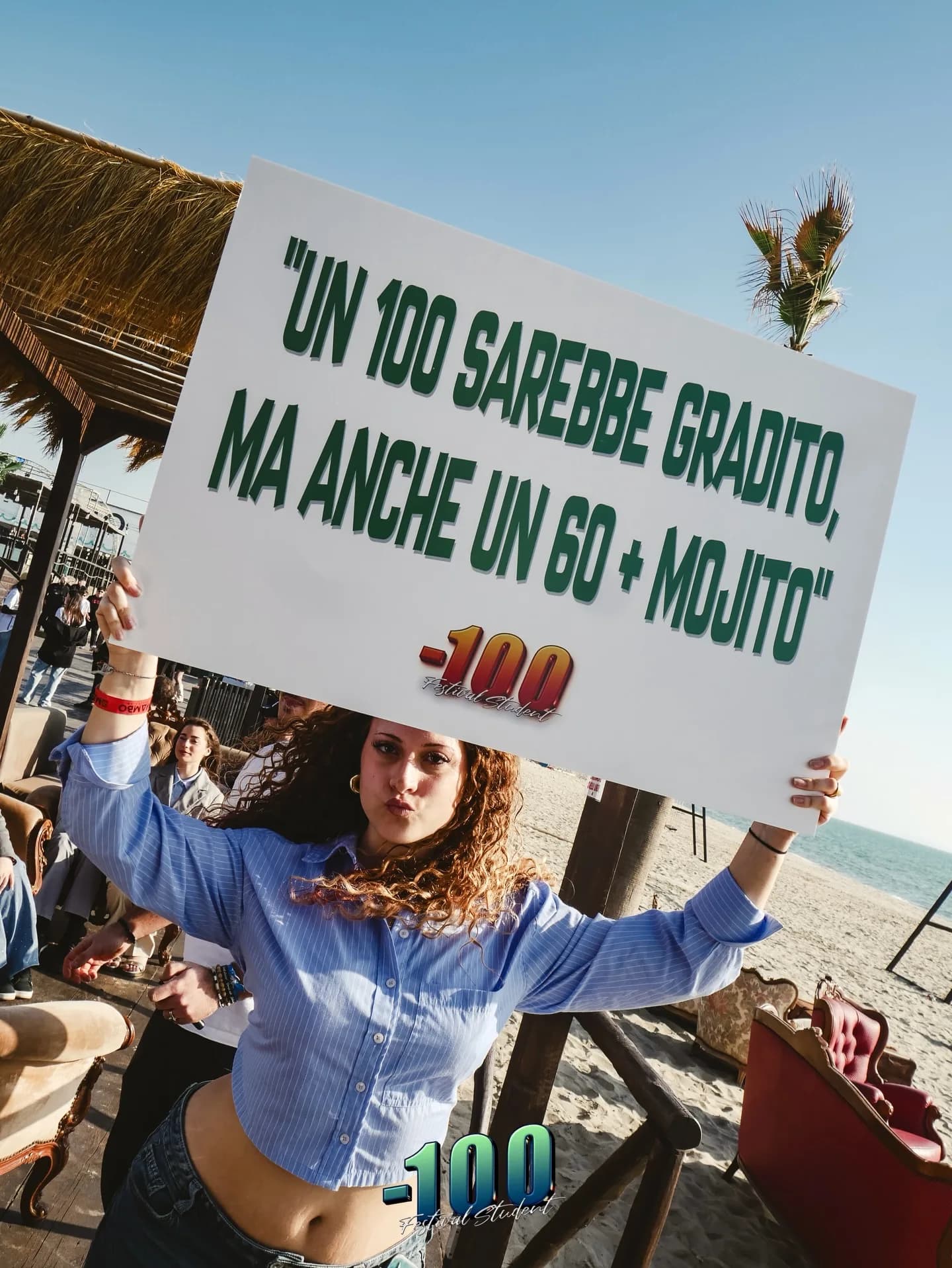 Una ragazza mostra un cartello con la scritta «Un 100 sarebbe gradito, ma anche un 60 + mojito».